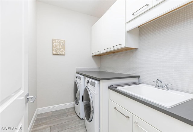 10138 Palazzo Dr, Naples, FL 34119 - laundry room with independent washer and dryer, cabinet space, light wood-style flooring, and baseboards