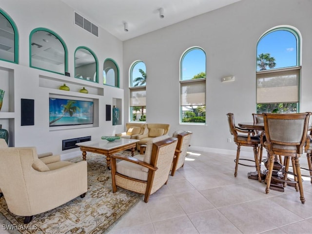 1079 Bald Eagle Dr Unit N604, Marco Island, FL 34145 - living room with built in shelves, light tile patterned floors, a towering ceiling, and baseboards