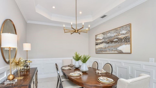 15315 Lucerna St Unit 201, Naples, FL 34114 - dining space with a chandelier, a tray ceiling, ornamental molding, recessed lighting, and a wainscoted wall