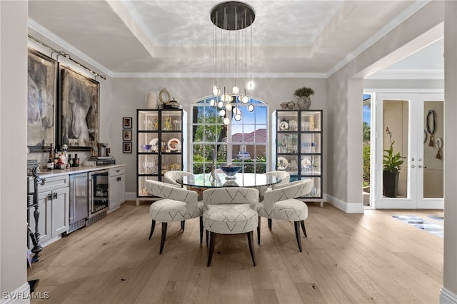 12501 Walden Run Dr, Fort Myers, FL 33913 - dining space featuring a raised ceiling, wine cooler, light wood-style flooring, a chandelier, and crown molding