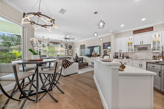 12501 Walden Run Dr, Fort Myers, FL 33913 - kitchen with crown molding, tasteful backsplash, open floor plan, light wood finished floors, and a ceiling fan