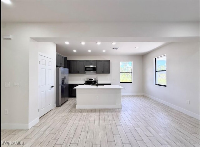 2917 50th St W, Lehigh Acres, FL 33971 - kitchen with appliances with stainless steel finishes, light wood-style flooring, open floor plan, light countertops, and recessed lighting