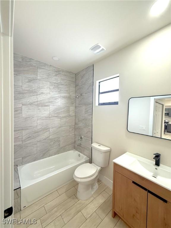 2917 50th St W, Lehigh Acres, FL 33971 - bathroom featuring toilet, vanity, shower / bathtub combination, and baseboards
