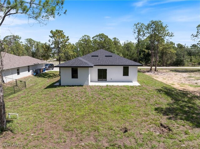 2917 50th St W, Lehigh Acres, FL 33971 - back of property featuring stucco siding, a shingled roof, and a patio area