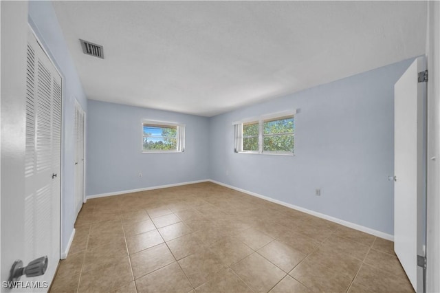 198 Joel Blvd Unit 5, Lehigh Acres, FL 33936 - unfurnished bedroom featuring light tile patterned flooring, baseboards, and a closet