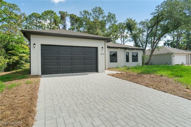 5015 Placid Ln, Labelle, FL 33935 - view of front facade featuring decorative driveway, a garage, and stucco siding