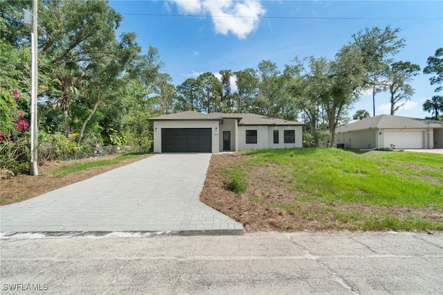 5015 Placid Ln, Labelle, FL 33935 - view of front facade featuring an attached garage, decorative driveway, stucco siding, and a front lawn