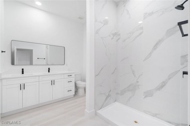 5015 Placid Ln, Labelle, FL 33935 - bathroom with double vanity, toilet, a marble finish shower, and wood finished floors