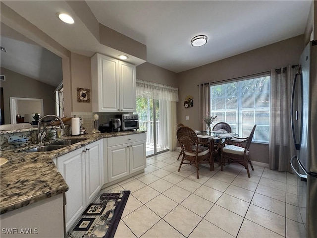 4219 Tequesta Dr, Estero, FL 33928 - kitchen with a sink, freestanding refrigerator, white cabinets, decorative backsplash, and recessed lighting