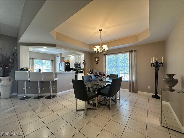 4219 Tequesta Dr, Estero, FL 33928 - dining space with a tray ceiling, a chandelier, light tile patterned flooring, and baseboards
