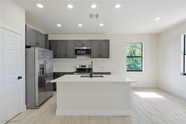 2907 55th St W, Lehigh Acres, FL 33971 - kitchen featuring stainless steel appliances, light wood-style floors, light countertops, a center island with sink, and recessed lighting