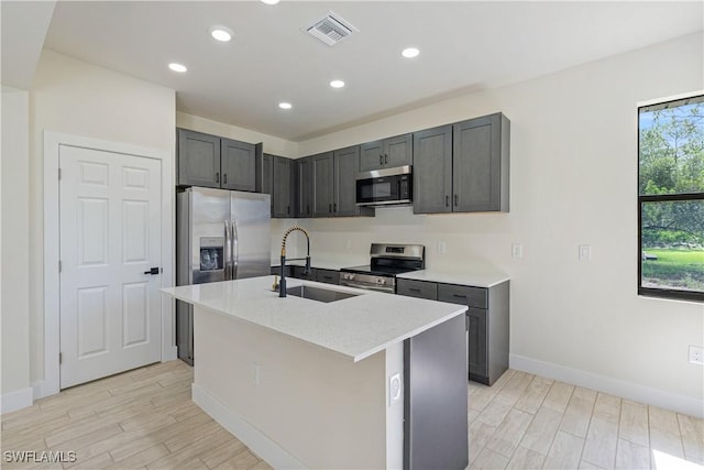 2907 55th St W, Lehigh Acres, FL 33971 - kitchen with appliances with stainless steel finishes, light wood-style flooring, recessed lighting, an island with sink, and light stone countertops