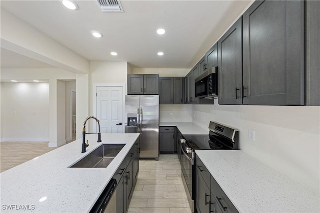 2907 55th St W, Lehigh Acres, FL 33971 - kitchen featuring appliances with stainless steel finishes, light stone countertops, recessed lighting, and light wood-type flooring