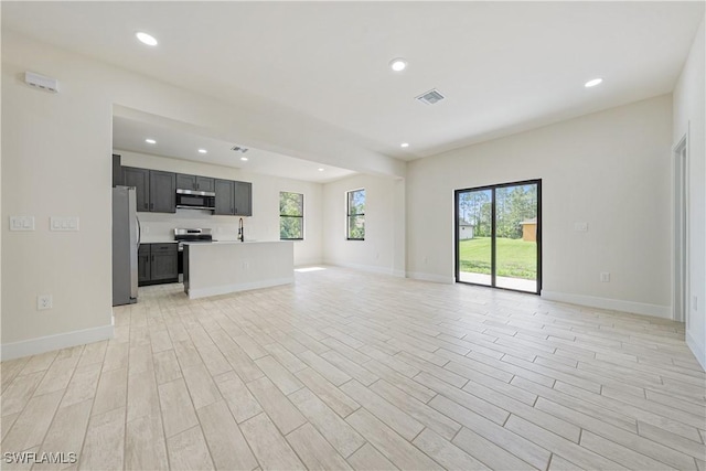 2907 55th St W, Lehigh Acres, FL 33971 - unfurnished living room featuring recessed lighting and light wood-type flooring