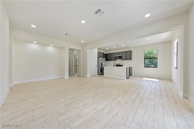 2907 55th St W, Lehigh Acres, FL 33971 - unfurnished living room featuring light wood finished floors and recessed lighting