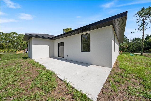 2907 55th St W, Lehigh Acres, FL 33971 - back of property featuring stucco siding, a patio area, and a yard