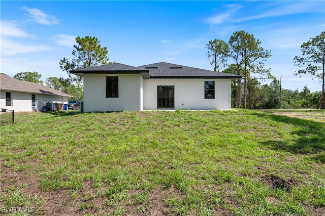 2907 55th St W, Lehigh Acres, FL 33971 - rear view of property featuring stucco siding and a lawn