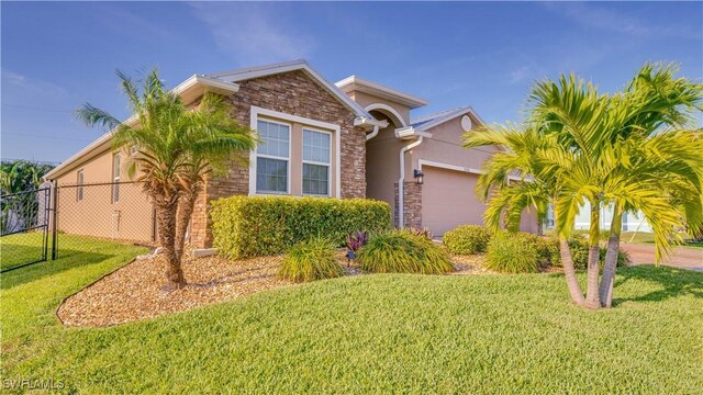 2541 SW 32nd Ln, Cape Coral, FL 33914 - view of front of home featuring stone siding, an attached garage, and stucco siding
