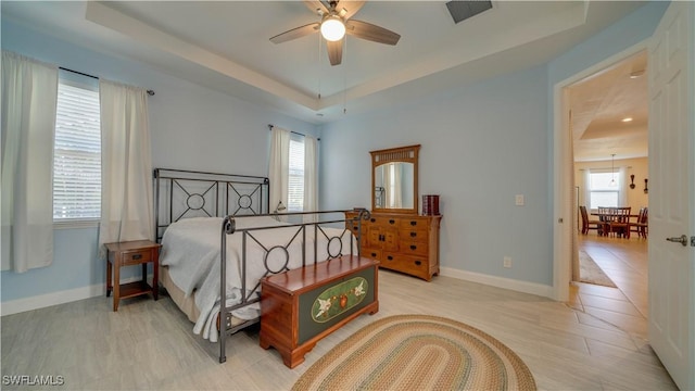 2541 SW 32nd Ln, Cape Coral, FL 33914 - bedroom featuring a tray ceiling, multiple windows, and baseboards
