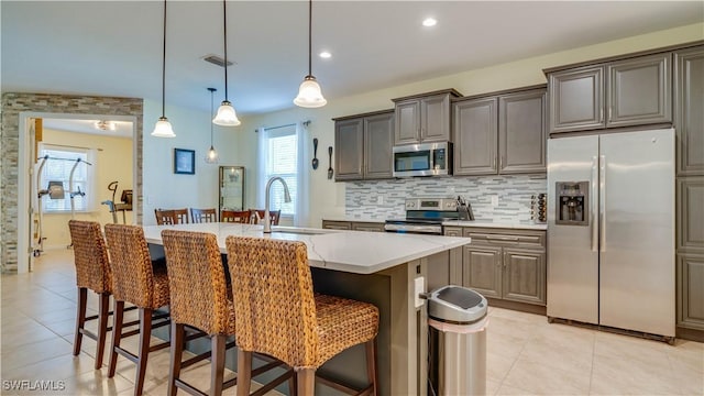 2541 SW 32nd Ln, Cape Coral, FL 33914 - kitchen featuring appliances with stainless steel finishes, a breakfast bar area, light countertops, light tile patterned flooring, and recessed lighting