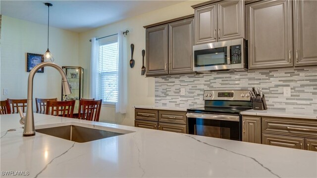 2541 SW 32nd Ln, Cape Coral, FL 33914 - kitchen with stainless steel appliances, backsplash, pendant lighting, and a sink