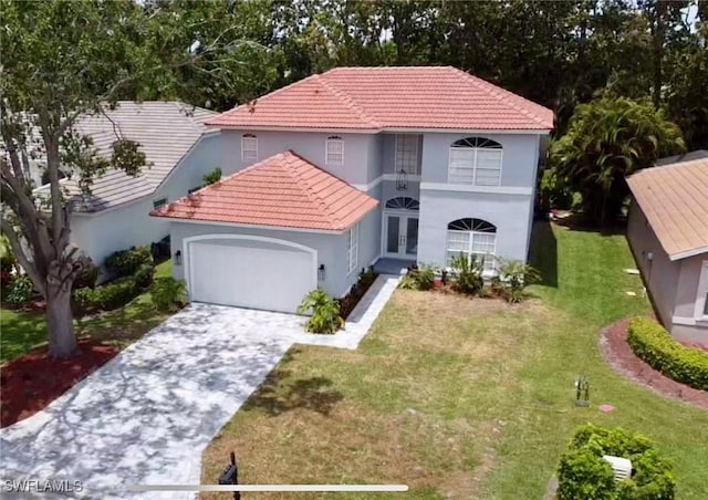25560 Springtide Ct, Bonita Springs, FL 34135 - mediterranean / spanish home with stucco siding, a garage, driveway, a front yard, and a tiled roof