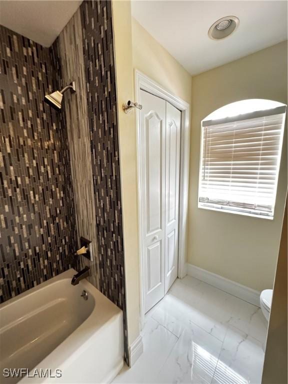 25560 Springtide Ct, Bonita Springs, FL 34135 - bathroom featuring marble look tiles, shower / tub combination, toilet, and baseboards