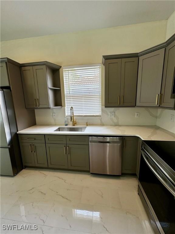 25560 Springtide Ct, Bonita Springs, FL 34135 - kitchen with stainless steel appliances, a sink, light marble finish floors, and light countertops