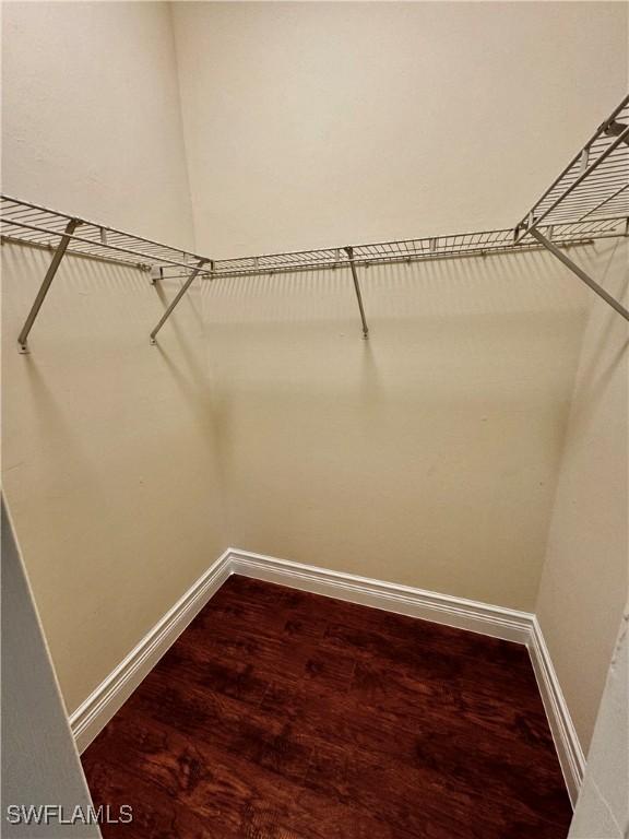 25560 Springtide Ct, Bonita Springs, FL 34135 - walk in closet featuring dark wood-style flooring