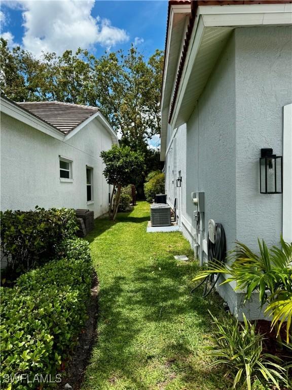 25560 Springtide Ct, Bonita Springs, FL 34135 - view of grassy yard featuring central AC