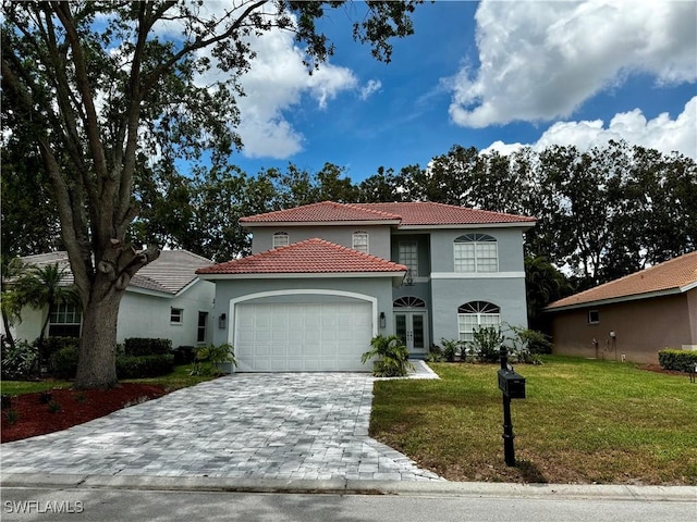 25560 Springtide Ct, Bonita Springs, FL 34135 - mediterranean / spanish house featuring an attached garage, a tiled roof, stucco siding, a front yard, and decorative driveway