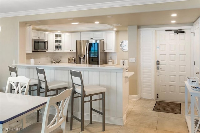 6672 Estero Blvd Unit A207, Fort Myers Beach, FL 33931 - kitchen featuring stainless steel appliances, tasteful backsplash, a breakfast bar, white cabinets, and ornamental molding