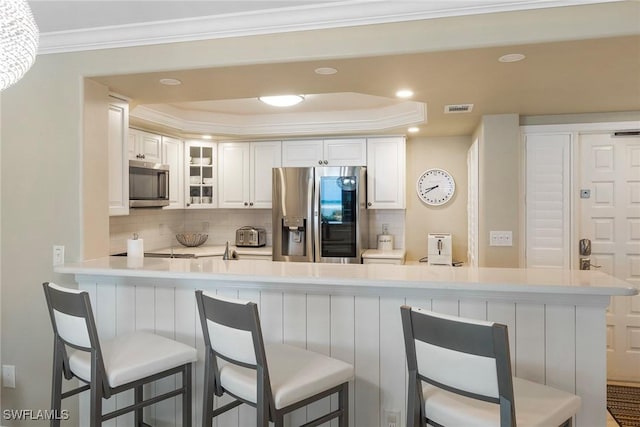 6672 Estero Blvd Unit A207, Fort Myers Beach, FL 33931 - kitchen with appliances with stainless steel finishes, decorative backsplash, glass insert cabinets, light countertops, and a peninsula