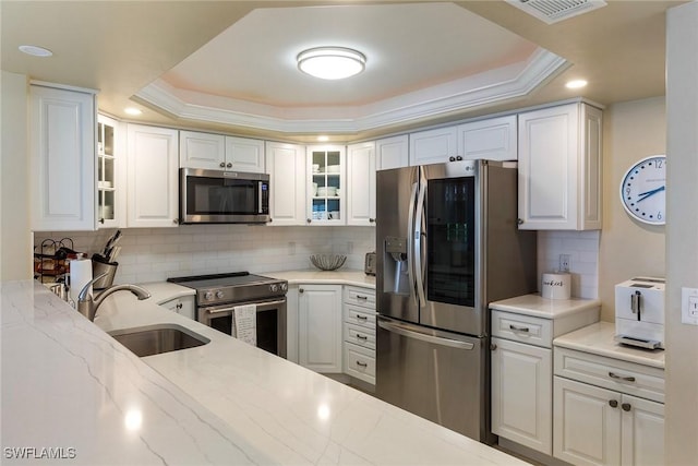 6672 Estero Blvd Unit A207, Fort Myers Beach, FL 33931 - kitchen featuring stainless steel appliances, a raised ceiling, light stone counters, tasteful backsplash, and recessed lighting