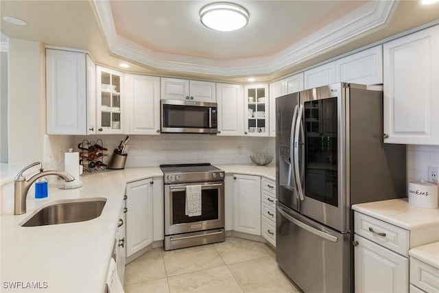 6672 Estero Blvd Unit A207, Fort Myers Beach, FL 33931 - kitchen with appliances with stainless steel finishes, a sink, tasteful backsplash, a tray ceiling, and white cabinetry