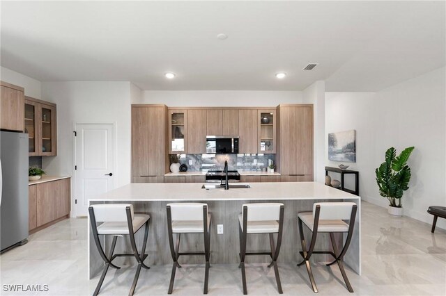 2308 NW 5th St, Cape Coral, FL 33993 - kitchen with stainless steel appliances, backsplash, a breakfast bar area, modern cabinets, and recessed lighting