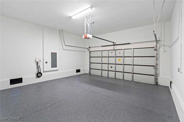 2308 NW 5th St, Cape Coral, FL 33993 - garage with electric panel, a garage door opener, and baseboards