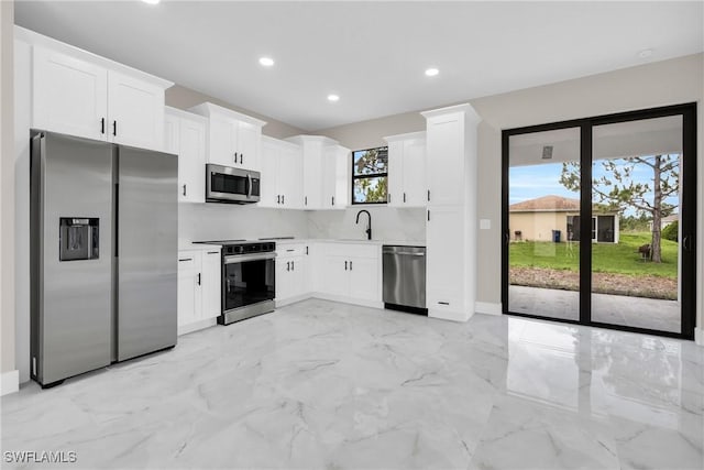 290731 St St W, Lehigh Acres, FL 33971 - kitchen featuring appliances with stainless steel finishes, recessed lighting, a sink, white cabinetry, and light marble finish flooring