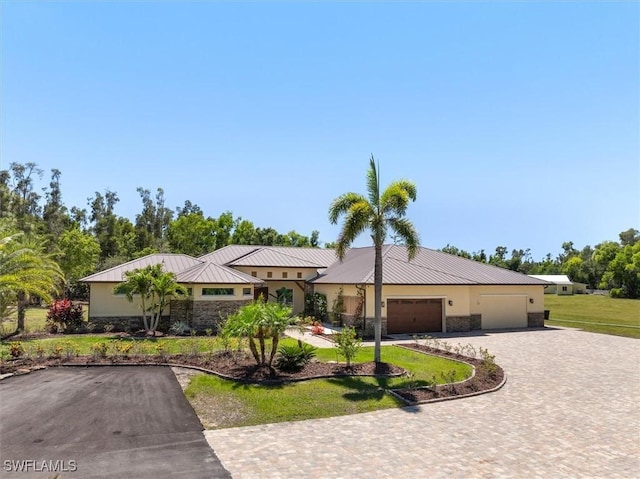 15860 Glendale Ln, Fort Myers, FL 33912 - view of front of property featuring stone siding, driveway, a garage, and metal roof