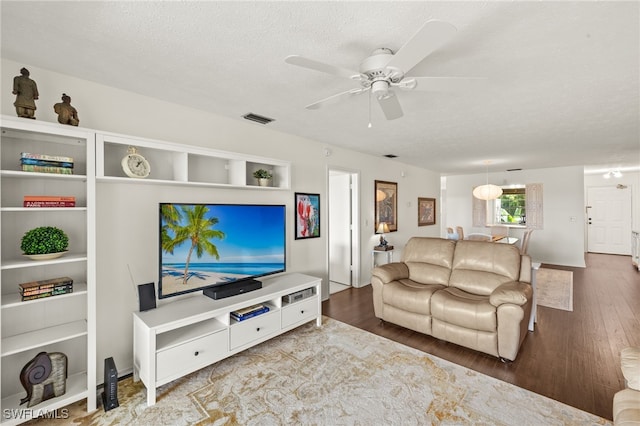 1345 SE 40th Ter Unit 2D, Cape Coral, FL 33904 - living room featuring wood finished floors, a ceiling fan, a textured ceiling, and baseboards