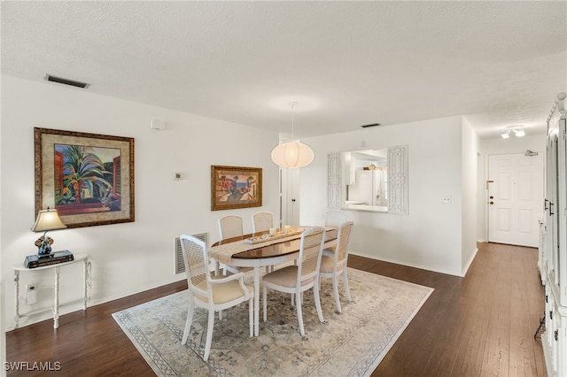 1345 SE 40th Ter Unit 2D, Cape Coral, FL 33904 - dining room featuring dark wood finished floors, baseboards, and a textured ceiling