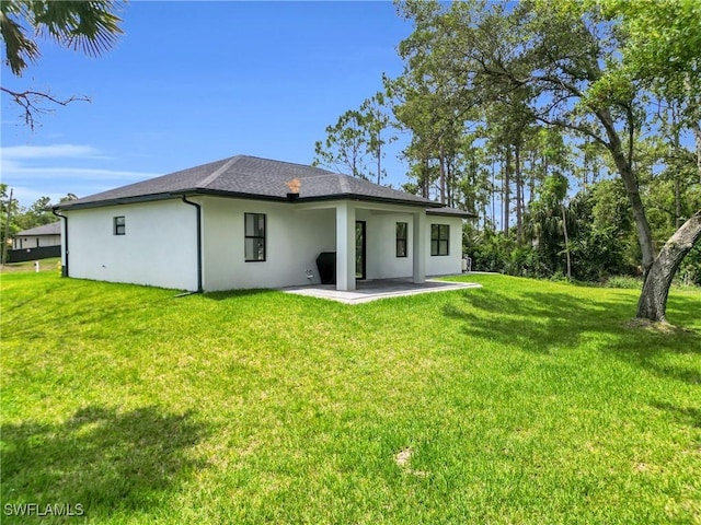 1914 Sunniland Blvd, Lehigh Acres, FL 33971 - back of house featuring stucco siding, a patio, and a lawn