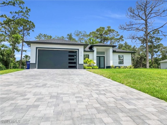 1914 Sunniland Blvd, Lehigh Acres, FL 33971 - view of front of house with decorative driveway, a front lawn, an attached garage, and stucco siding