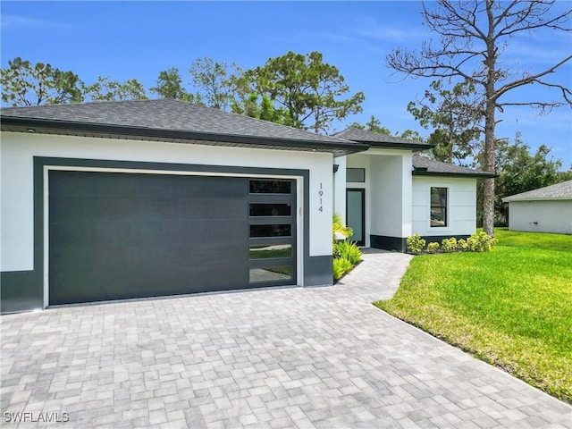 1914 Sunniland Blvd, Lehigh Acres, FL 33971 - view of front of property with stucco siding, a front yard, an attached garage, roof with shingles, and driveway