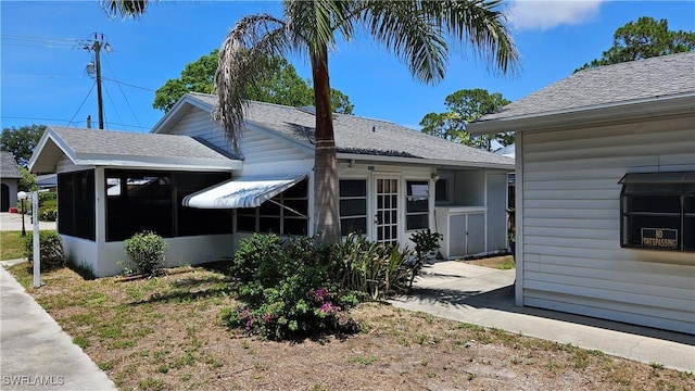 27625 Michigan St, Bonita Springs, FL 34135 - view of side of property featuring a sunroom and roof with shingles