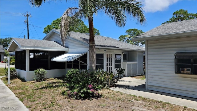 27625 Michigan St, Bonita Springs, FL 34135 - view of side of property featuring a sunroom and roof with shingles