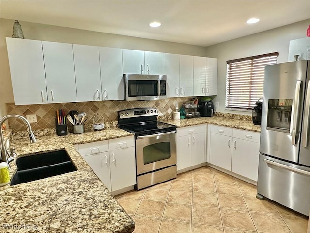 352 Paisley Ave, Lehigh Acres, FL 33974 - kitchen featuring appliances with stainless steel finishes, backsplash, white cabinetry, light stone countertops, and recessed lighting