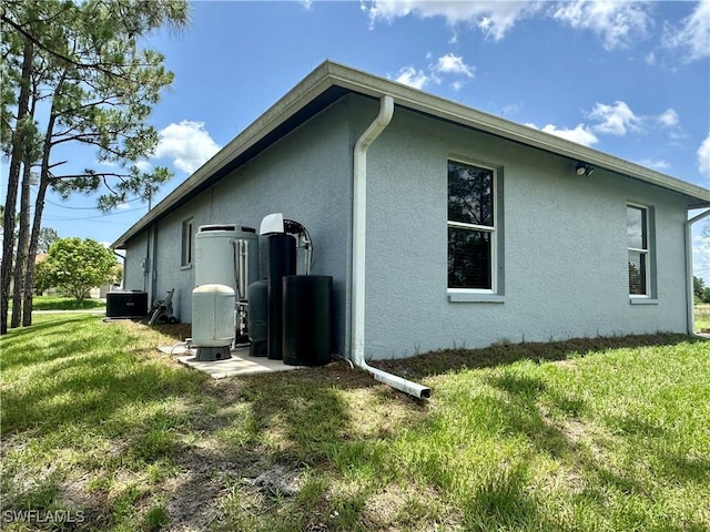 352 Paisley Ave, Lehigh Acres, FL 33974 - view of property exterior featuring stucco siding and a yard