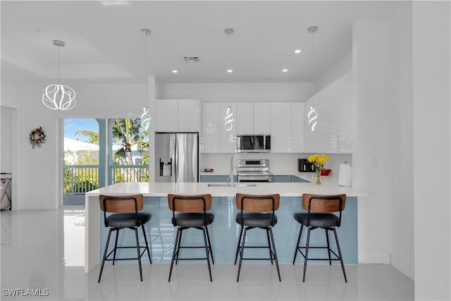 518 Avenida Primiceria, Marathon, FL 33050 - kitchen featuring appliances with stainless steel finishes, a peninsula, white cabinets, modern cabinets, and a kitchen bar