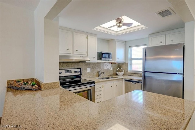 5000 Estero Blvd Unit 202, Fort Myers Beach, FL 33931 - kitchen featuring appliances with stainless steel finishes, under cabinet range hood, a sink, light stone counters, and a skylight